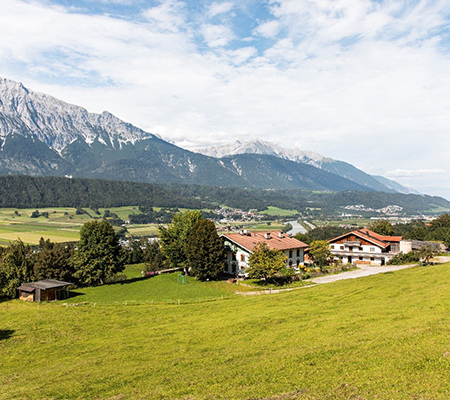 Klimabündnisbetrieb Aufbauwerk Volders in Bergpanorama und blauen Himmel in Innsbruck