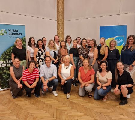 Gruppe von Menschen vor zwei Roll-Ups, lächeln in die Kamera