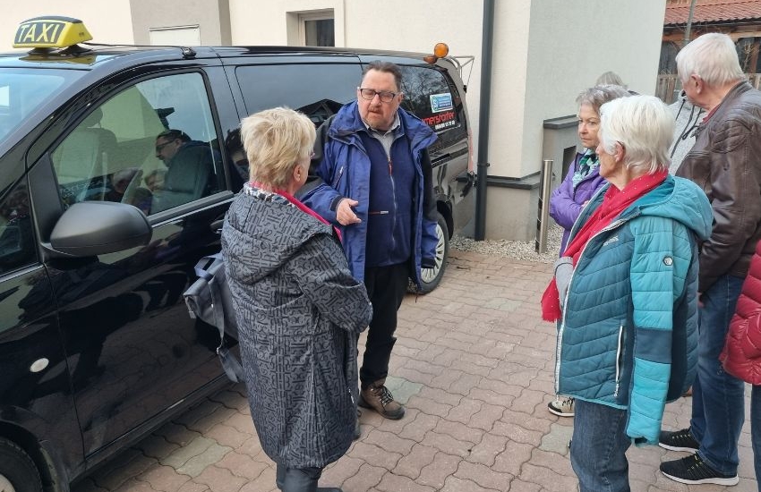 mehrere ältere Menschen stehen draußen und reden