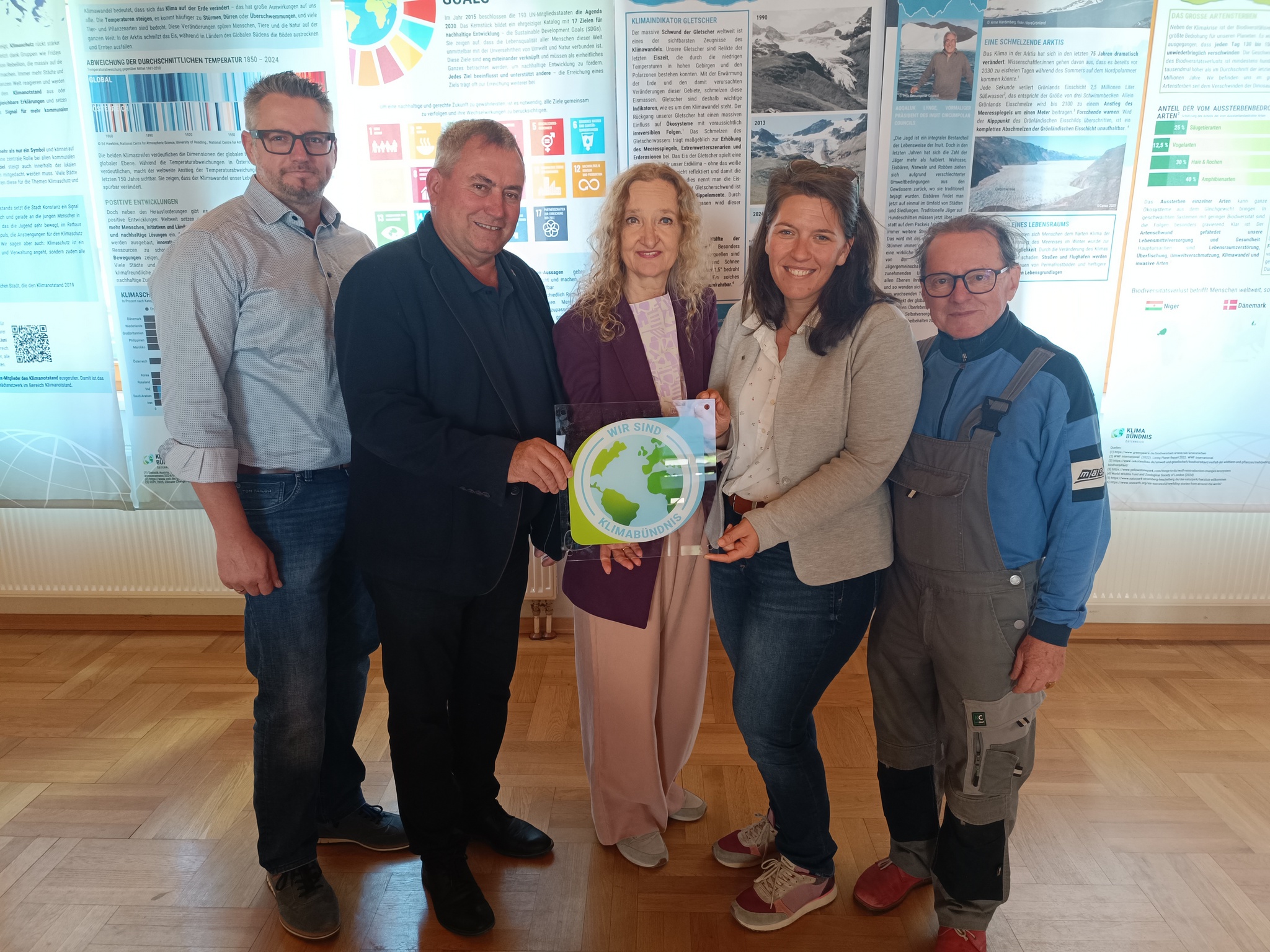 5 Menschen stehen vor Ausstellunsbahnen für ein Pressefoto.
